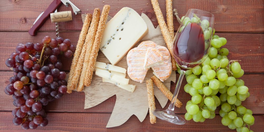 Cheese platter with red wine and fresh grapes